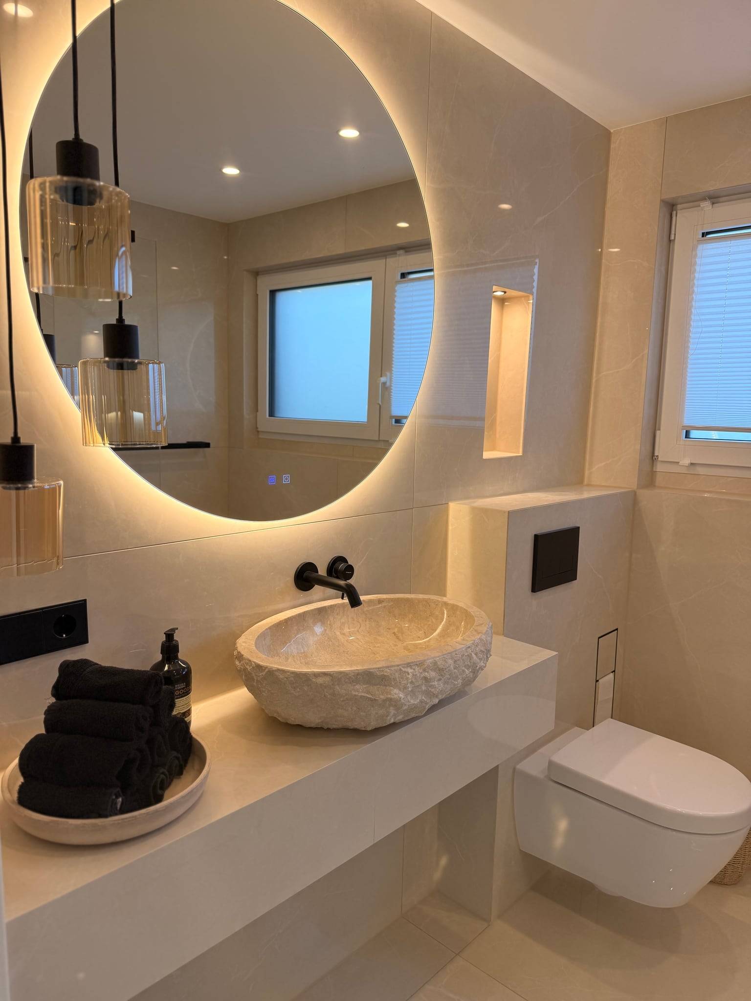 Gäste-WC mit cremefarbenem XXL-Feinsteinzeug, Naturstein-Aufsatzbecken und beleuchtetem Rundspiegel